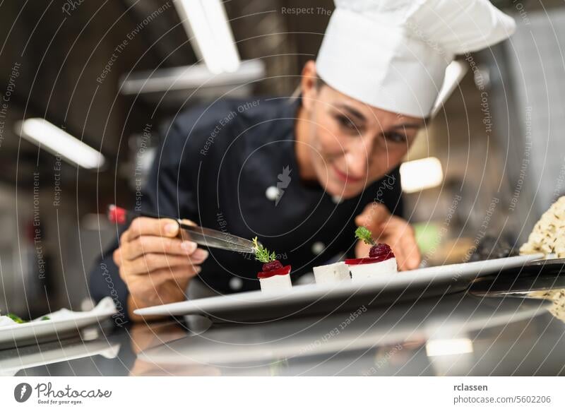 Chef Perfecting a Gourmet dessert adding green topping finishing dish, decorating meal in the end. Luxury hotel cooking concept image. trendy sugar art sweet