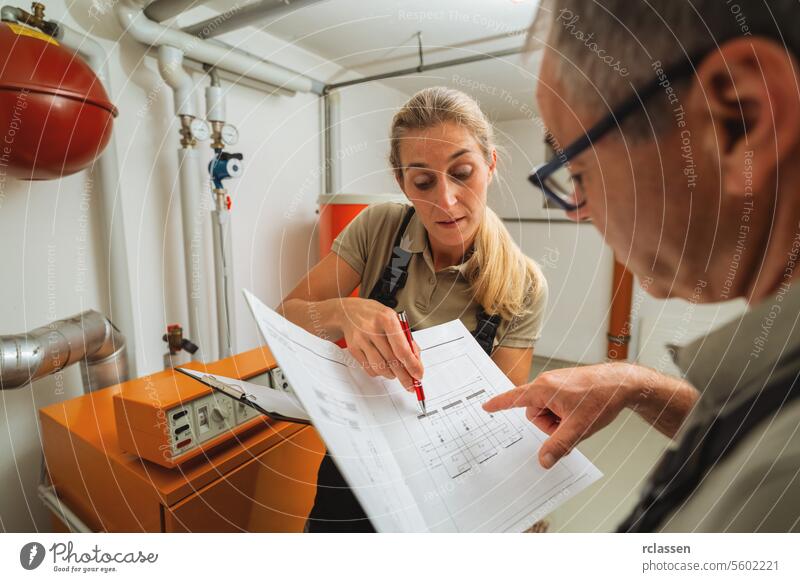 Team of heating engineers checks a old gas heating system with a paper instruction at a boiler room in a house. Gas heater replacement obligation concept image