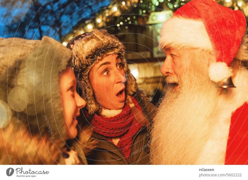 Woman and child in shock and joy meeting Santa Claus at a Christmas market tourist merry christmas traditional mulled wine christmas market advent german xmas