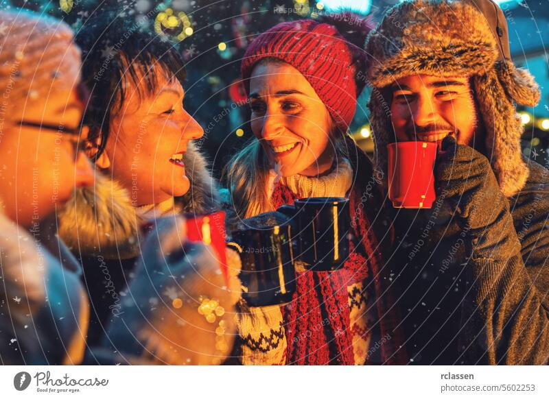 Friends drinking mulled wine at a Christmas market punch merry christmas cup hot chocolate gloves traditional christmas market advent german snowflakes holiday