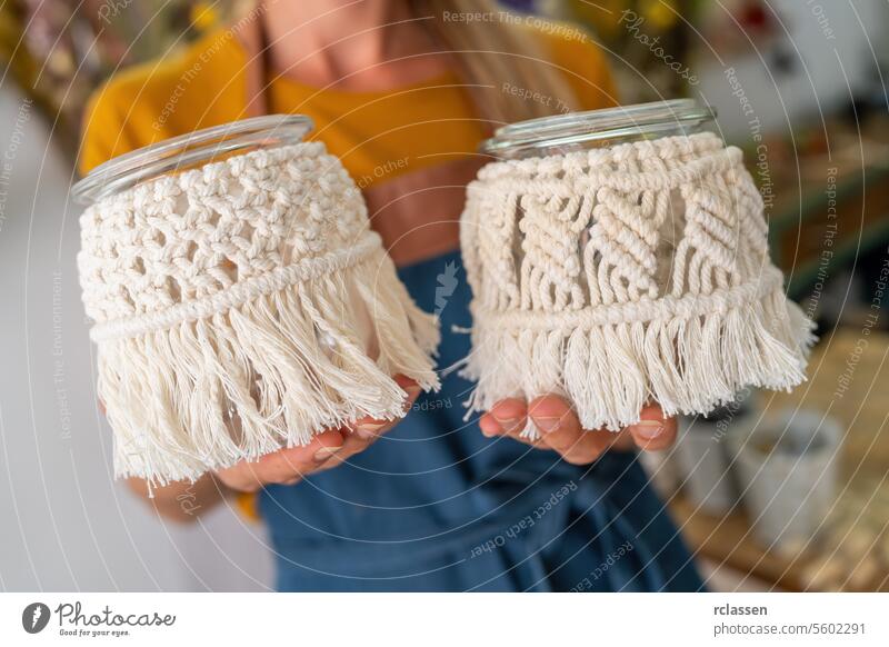 Close-up of hands holding macrame decorated glass jars decorated jars close-up crafting diy handmade decoration macrame decoration texture creative art hobby