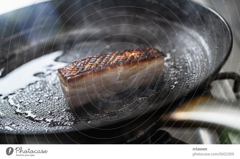 Crispy pork Roast in hot pan with oil at a gas stove in a professional kitchen at a restaurant. Luxury hotel cooking concept image. crust cuisine steam