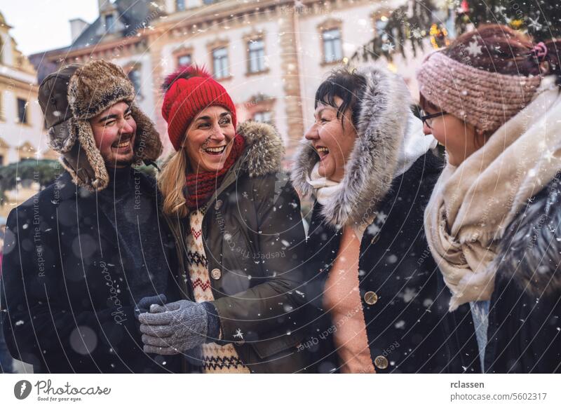 Joyful friends sharing a laugh in a snowy Christmas market meeting merry christmas cup hot chocolate gloves traditional mulled wine christmas market advent