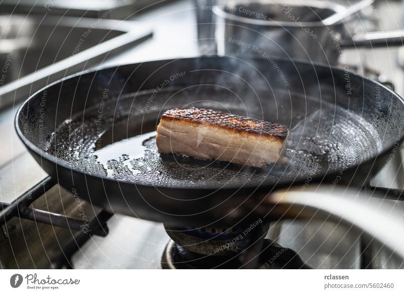 Crispy pork belly Roast in hot pan with oil at a gas stove in a professional kitchen at a restaurant. Luxury hotel cooking concept image. crust cuisine steam