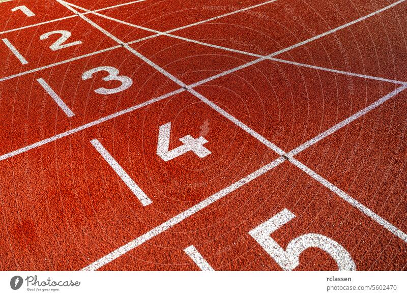 Close-up of lane numbers on a red running track, textured surface, no people athletics sport red track close-up track and field numbered lanes lines competition