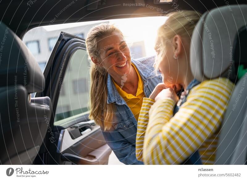 Happy mother and daughter in car. Safety driving concept image sunlight scarecrow sitting smiling backseat blond kid woman girl germany child chair safety belt