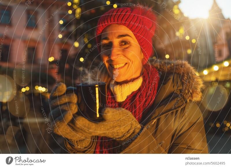 Happy woman in front of Christmas tree on Christmas market drinking hot wine at winter steam december hot chocolate xmas austria munich food hangout bokeh
