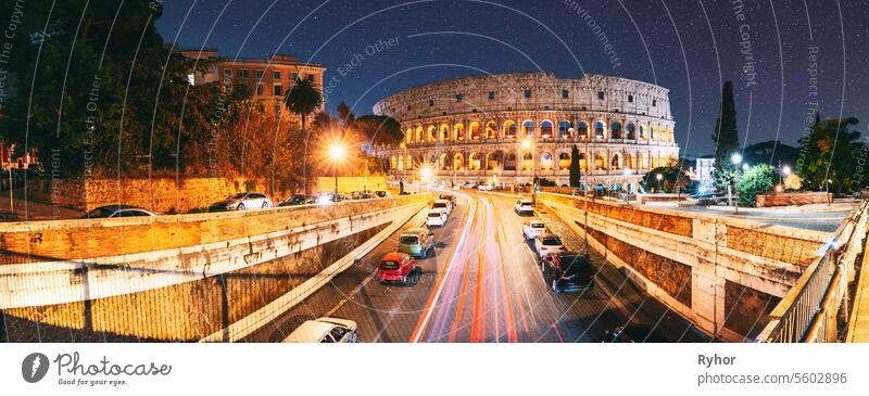 Rome, Italy. Colosseum Also Known As Flavian Amphitheatre. Traffic In Rome Near Famous World Landmark UNESCO In Evening Time. Amazing Bright Night Starry Sky Background. Dark Blue Sky. Travel Italy