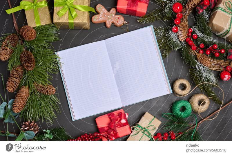 Open notebook with blank sheets on the table in the middle of Christmas decor, top view holiday surprise gift writing decoration box paper cozy peace relaxation