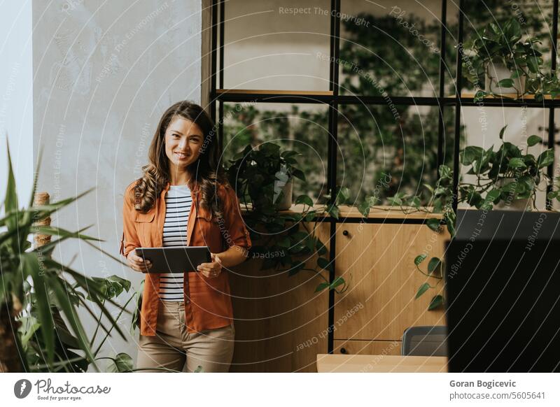 Young woman standing with digital tablet at the office american business business people businesswoman career caucasian alone communication corporate coworkers