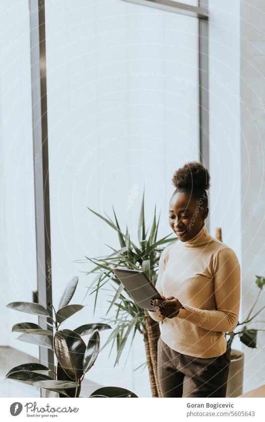 One young African American business woman with digital tablet standing wall in the office adult african american black businesspeople businesswoman