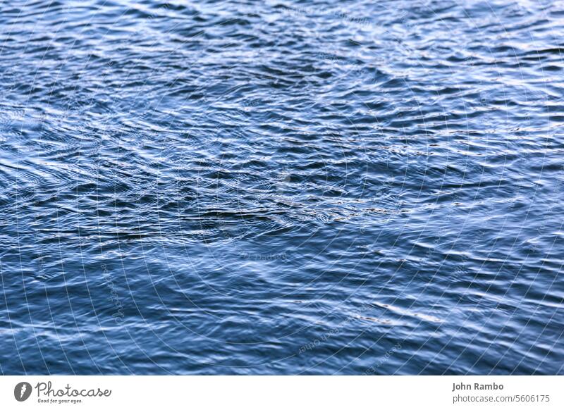 abstract water surface closeup with small plain ripples and selective focus background clean nobody blur blue reflections depth of field shallow wallpaper