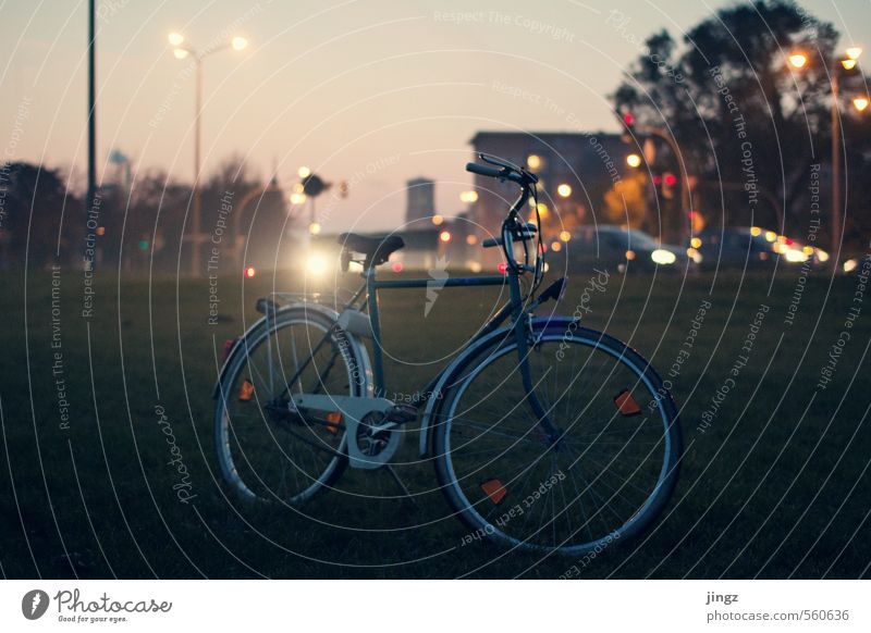 Someones bike Bicycle Means of transport Stand Wait Dark Town Green Orange Pink Flexible Unwavering Loneliness Fitness Contentment Stagnating Blur Colour photo