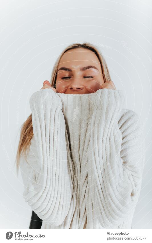 Yyoung blonde woman, dressed in white sweater, wrapped in a collar, looking at camera, white background studio lovely posing caucasian soft portrait knitwear