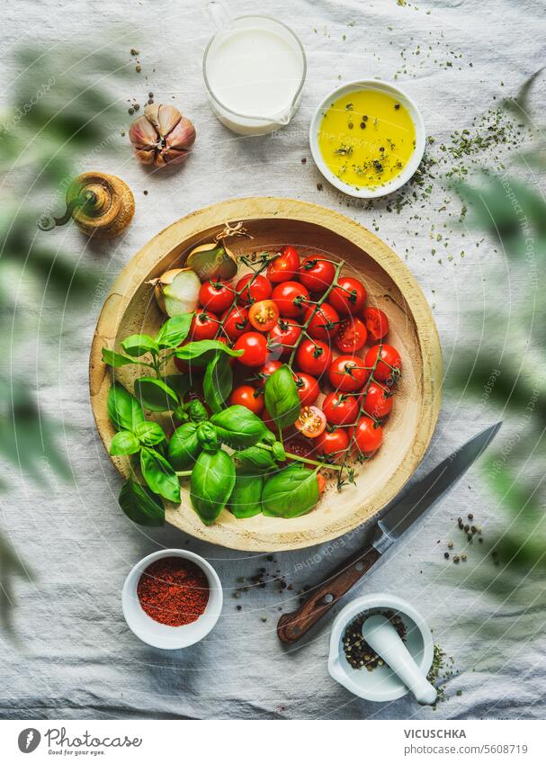 Italian food cooking with fresh tomatoes and basil leaves on table with other ingredients, top view italian food cherry tomatoes healthy eating raw garlic