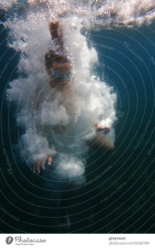 Underwater swimmer surrounded by bubbles underwater boy vacation relax adventure air aquatic dive diver diving holiday pool sea sport submerged summer swimming