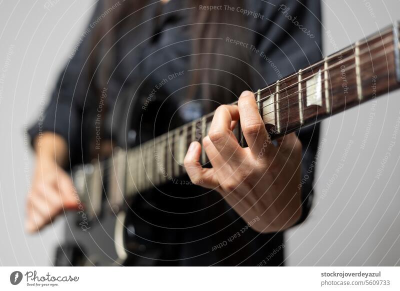 Detail of a female guitarist's hands while playing chords on the electric guitar musical woman musician rock instrument sound concert player background string