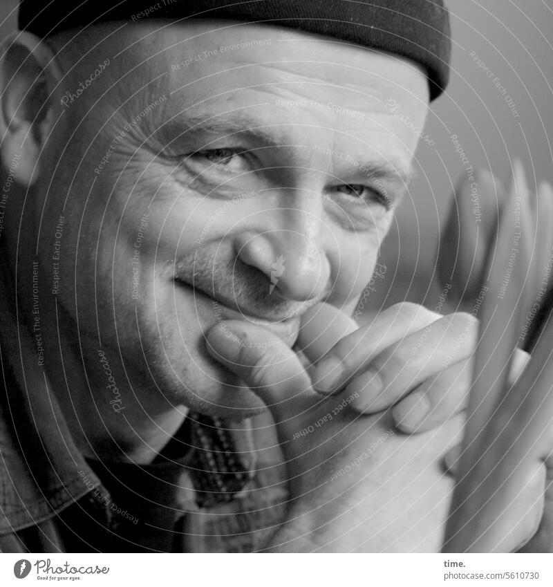 lächelnder Mann mit Mütze aufstützen Portrait freundlich zufrieden schmuzlen vergnügt heiter