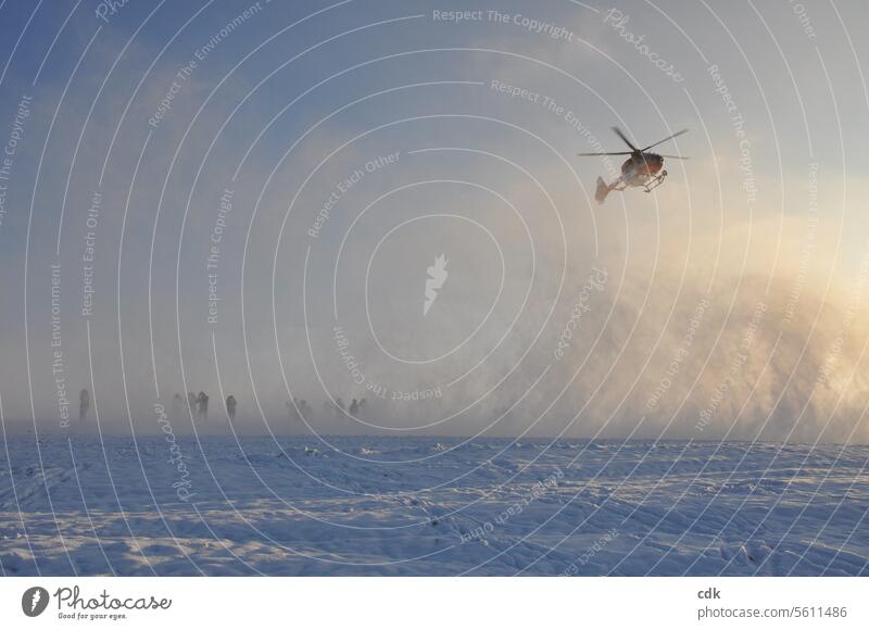 A cold, sunny winter's day: suddenly a helicopter from the air rescue service appears in the sky and creates a snowstorm as it lands. Helicopter Technology