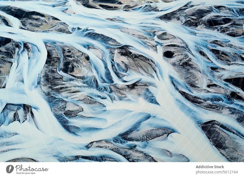 Aerial view of a snow-covered river basin in Iceland iceland aerial view pattern terrain landscape natural winter cold waterway stream flow topography texture
