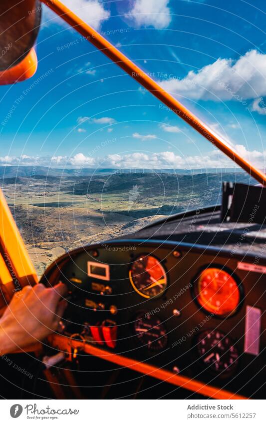 Cockpit view of Anonymous crop person Piloting a Small Aircraft Above the Clouds piloting small aircraft clouds landscape pilot's hand controls flying