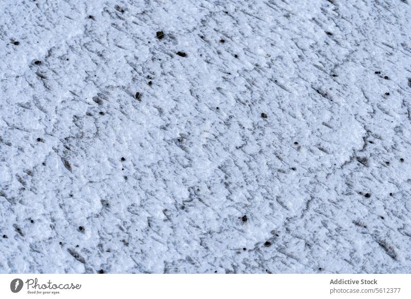 Textured Ice Surface with Embedded Debris ice texture surface close-up debris speckled pattern background cold winter frost frozen detail nature outdoor white