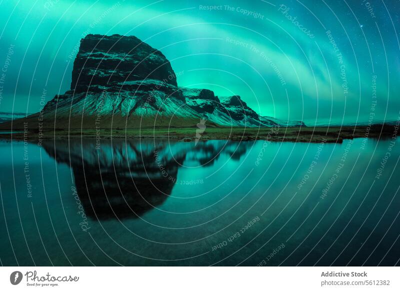 Northern lights and reflection over an Icelandic mountain iceland northern lights aurora borealis night sky water landscape nature travel serene scenic evening