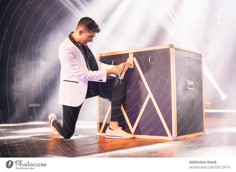 Magician locking box on stage during performance magician show trick key illusion male illusionist performer conjurer mystery illuminate artist projector skill
