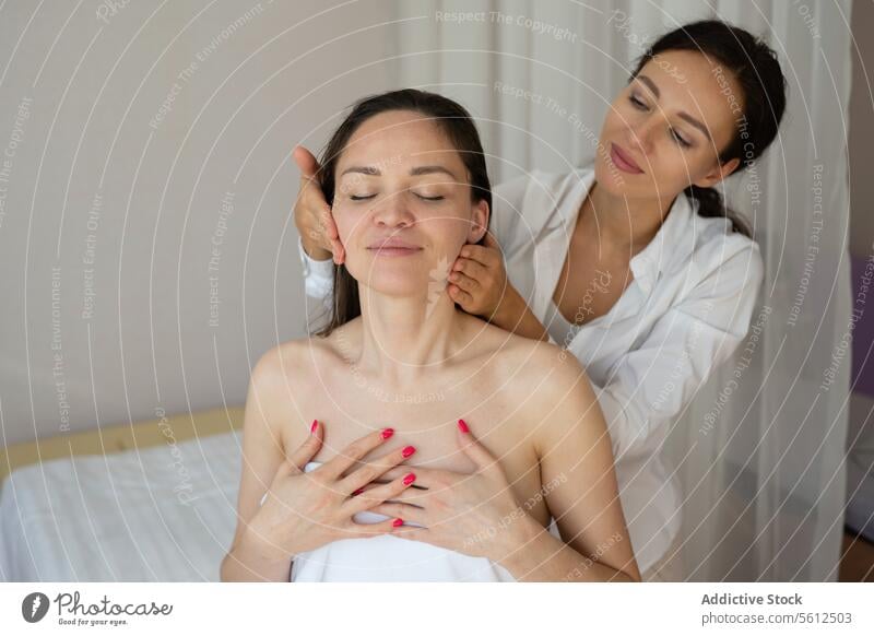 Crop hands of unrecognizable masseuse doing hair massage to topless female customer enjoying therapy with closed eyes in spa session head eyes closed crop sit