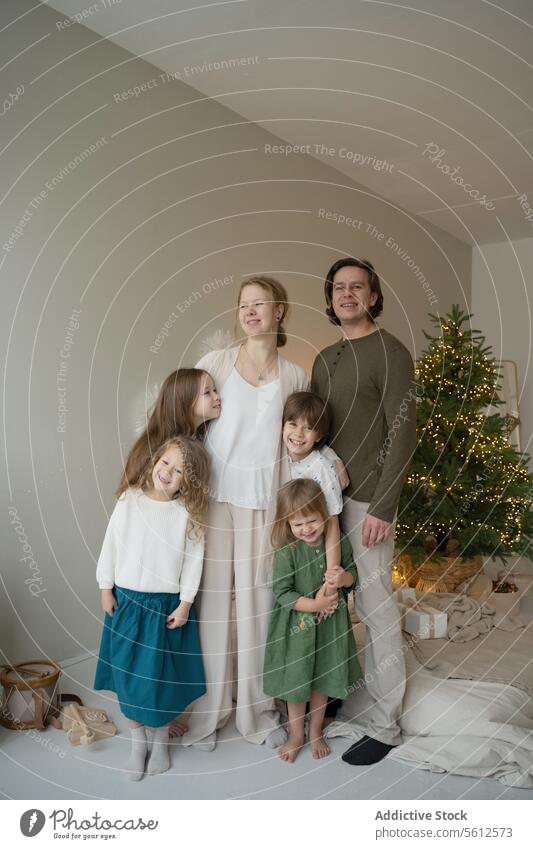 Family holiday portrait with Christmas tree backdrop family christmas festive happy photo decor warmth celebration parents children togetherness moment capture