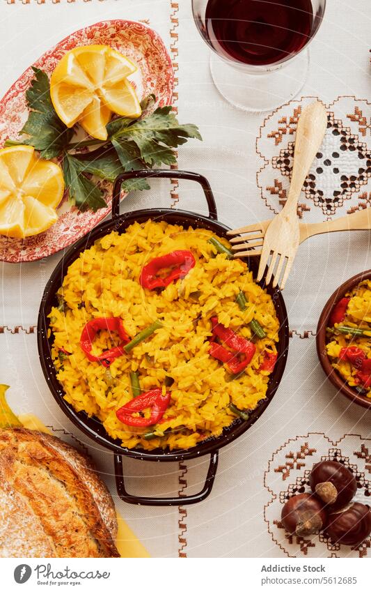 Authentic Spanish paella served with bread and wine spanish cuisine traditional rice seafood overhead view tablecloth pattern meal dinner lunch serving dish
