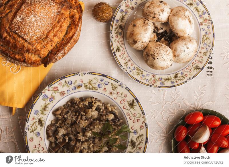 Rustic table setting with traditional food dishes rustic risotto home-cooked fresh ingredients plate mushroom tomato fabric textile bread lunch meal cuisine