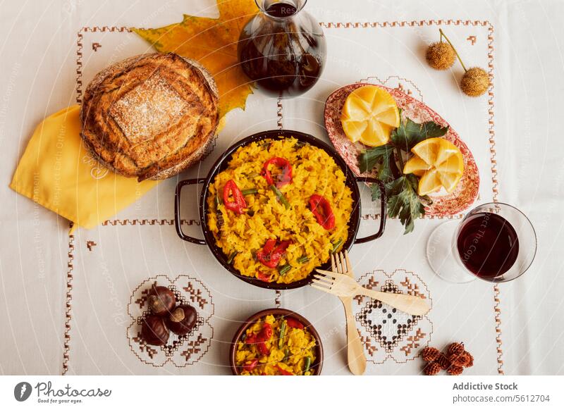 Authentic Spanish paella served with bread and wine spanish cuisine traditional rice seafood overhead view tablecloth pattern meal dinner lunch serving dish
