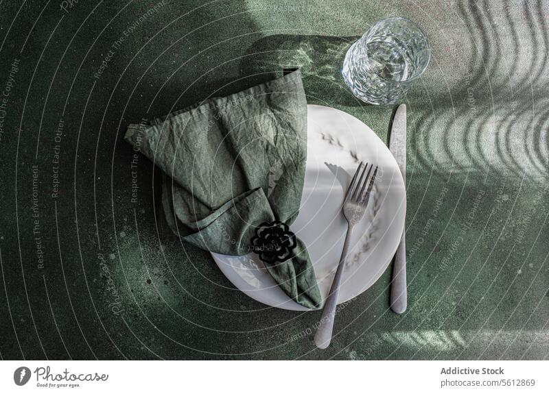 Elegant Table Setting with Shadow Play and Reflections table setting elegant shadow reflection white plate cutlery napkin ring glass playful sophistication