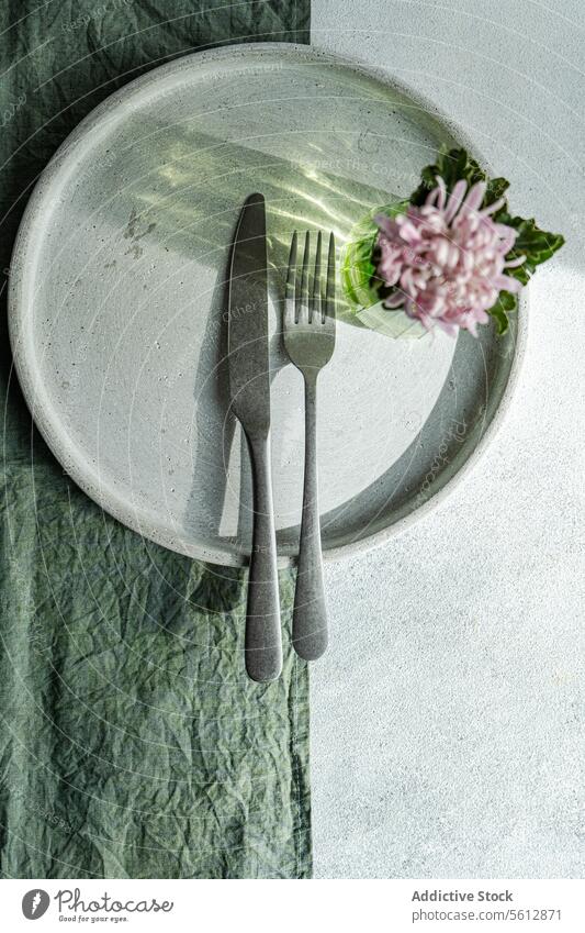 Elegant table setting with floral accent plate cutlery fork knife flower cloth textile top-down view chic elegant fresh texture fabric dining decor tableware