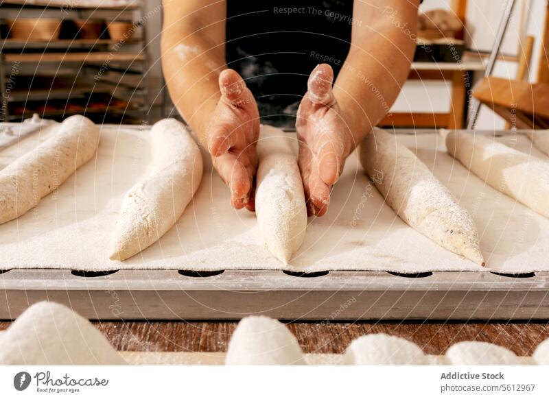 Hands of man making bread in bakehouse baker dough loaf shape hand crop raw flour tray food table kitchen bakery body part fresh handmade chef uncooked