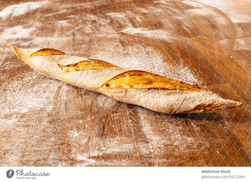 Fresh crunchy baguette on table in bakery bread loaf fresh crispy crust wooden bakehouse kitchen closeup baked tasty whole wheat healthy french organic flour