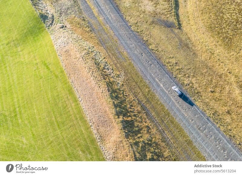Aerial view of a car driving through Iceland's Highlands on sunny day iceland highlands thorsmork valley aerial road solitary landscape contrast rugged winding
