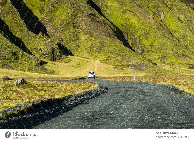 Back view of vehicle on road in Thorsmork valley, Icelandic highlands on sunny day iceland thorsmork scenic drive car travel green slope untouched landscape