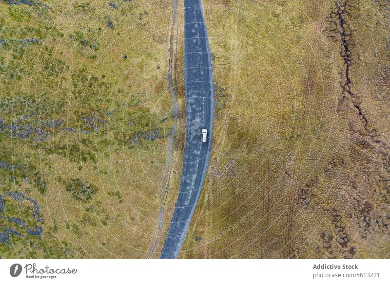 Aerial view of a vehicle with opened door on a road in Iceland's highlands iceland aerial thorsmork valley rugged terrain winding shot lone travel remote