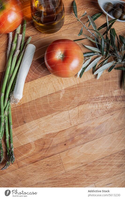 Fresh vegetables and olive oil on a wooden board tomato asparagus leek rustic cutting board food ingredient fresh ripe culinary background cooking healthy