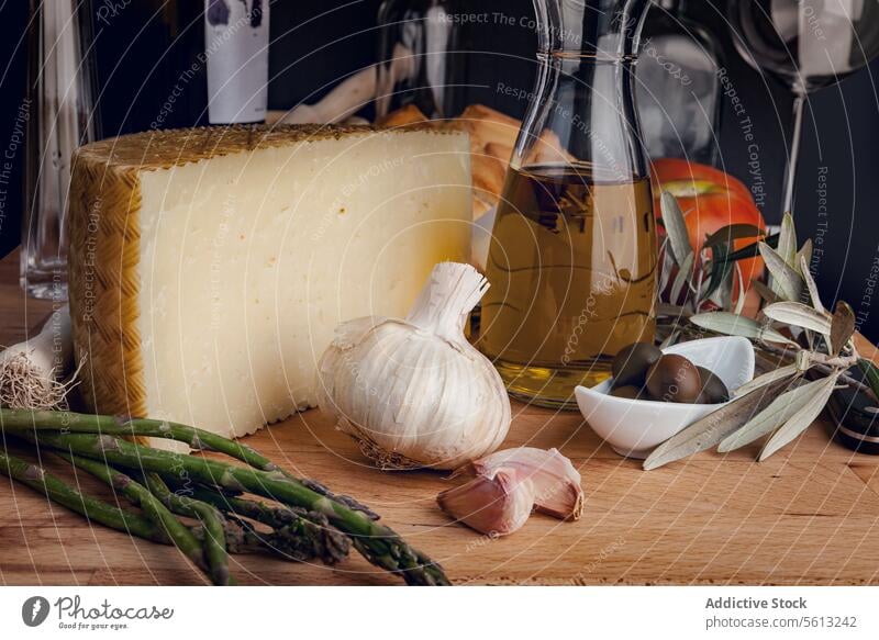 Gourmet cheese and ingredients on a rustic table artisanal garlic asparagus olives olive oil meal prep gourmet food cooking kitchen cuisine mediterranean