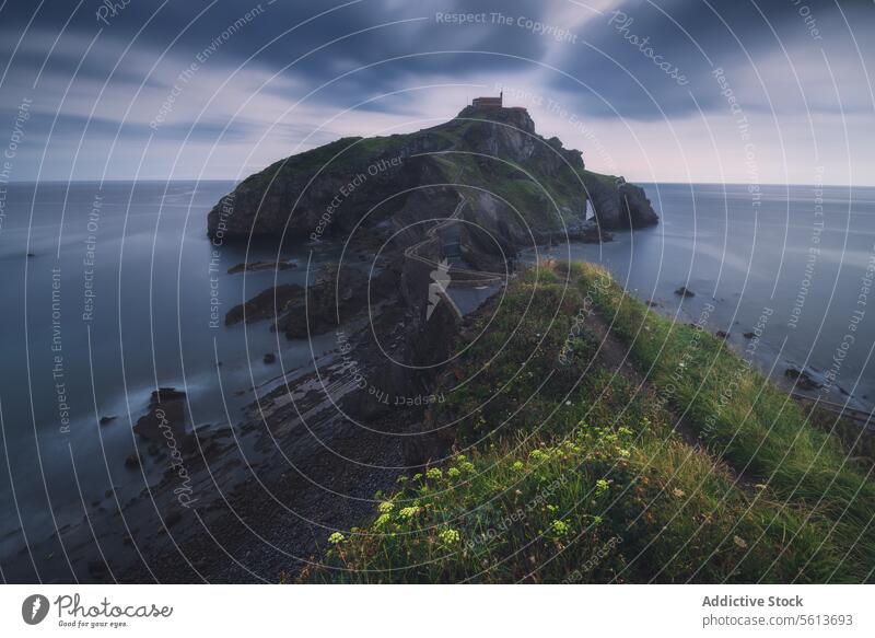 Hermitage of San Juan de Gaztelugatxe perched on a rugged cliff castle twilight serene secluded sea hermitage calm landscape outdoor scenic tranquil dusk