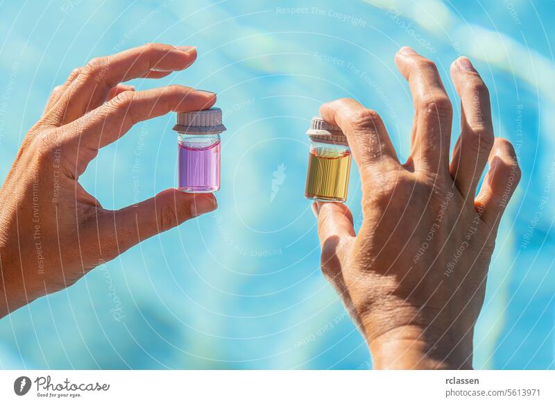 Hands holding vials with pink and yellow liquids for pool water pH testing at a hotel wellness spa resort ink liquid value chlorine measure sample hygiene