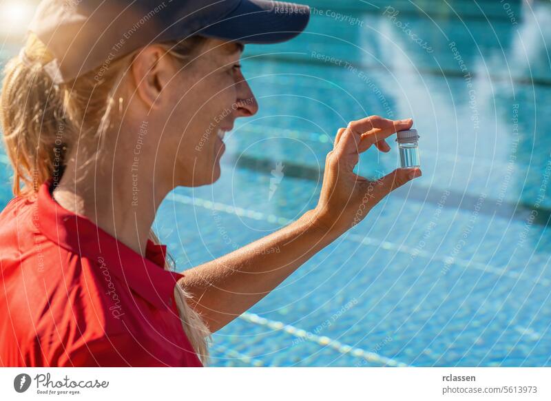 smiling pool technician holding up a small vial of pool water for pH testing ink liquid yellow liquid value chlorine measure sample hygiene summer investigate