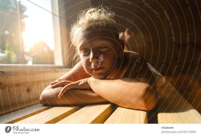 Child resting on a sauna bench, sunlight filtering through a window, eyes closed hotel bathrobe beauty spa calm comfortable enjoy sweat finland finnish child