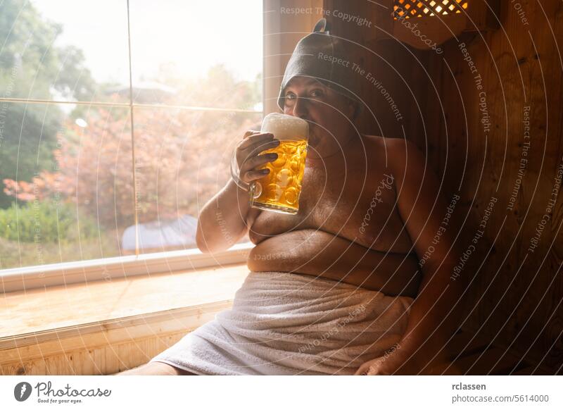 Man in a finnish sauna wearing a felt hat, sipping on a german beer mug, with a bright window in the background. Oktoberfest concept image oktoberfest bavaria