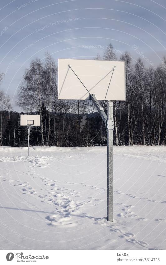 Basketball court covered with snow on a winter day with no people Exterior shot Sports Playing Basketball basket Court building basketball Playground