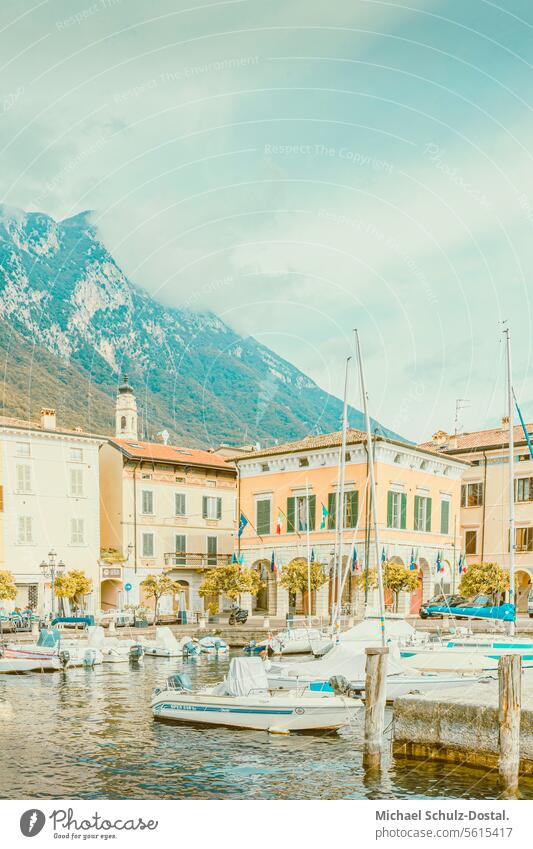 Picturesque harbor of Gargnano in front of the cloud-shrouded mountains Lago Garda Lake Italy Lombardy Water Harbour seascape port picturesque lake view pastel