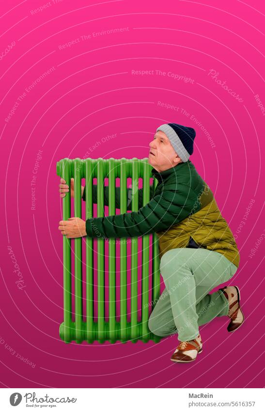 Man warms himself up on a green radiator Old heating Old man elderly person Poverty Expenditure A human Single person single human Energy efficiency